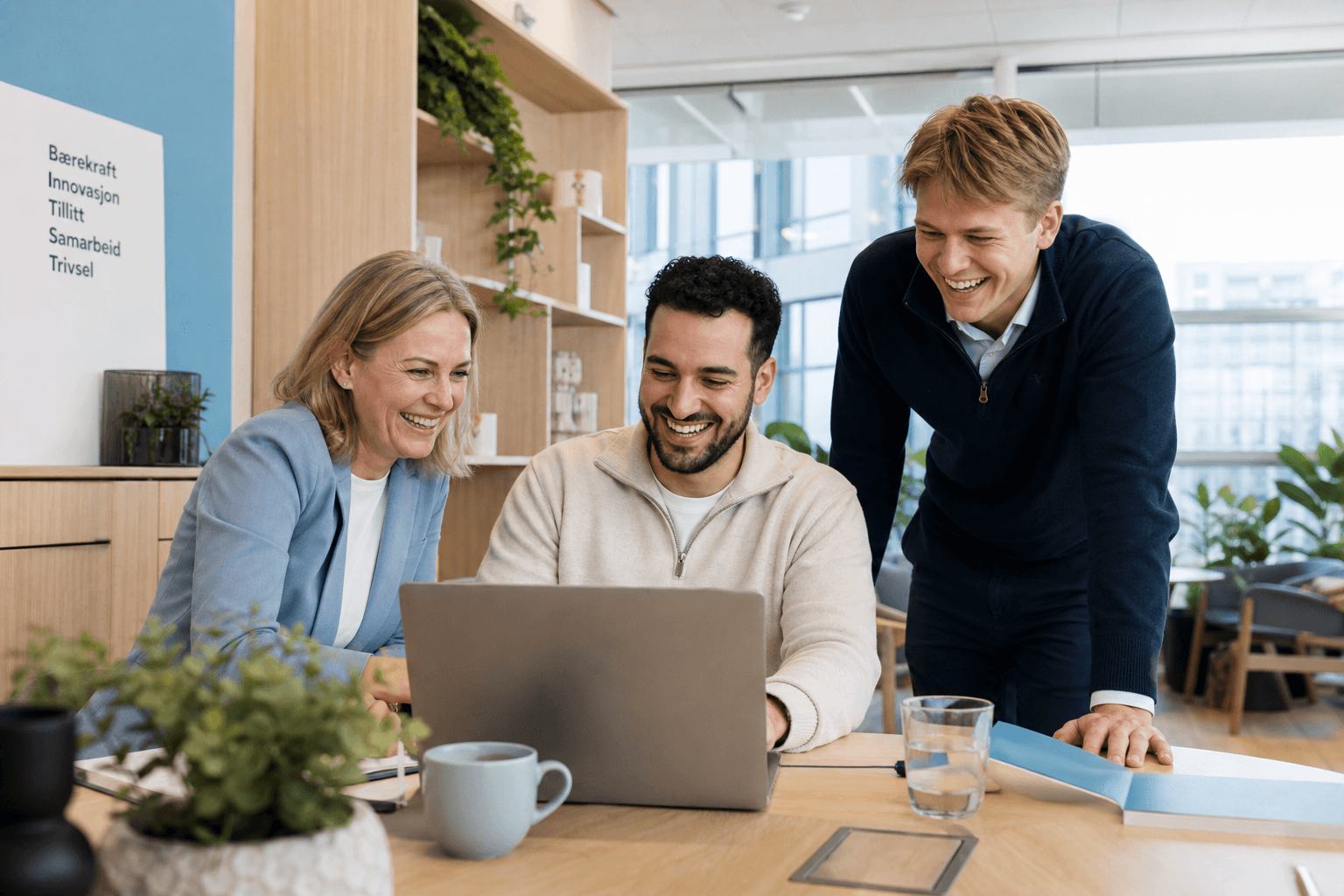 Team som ser fornøyd på en laptop